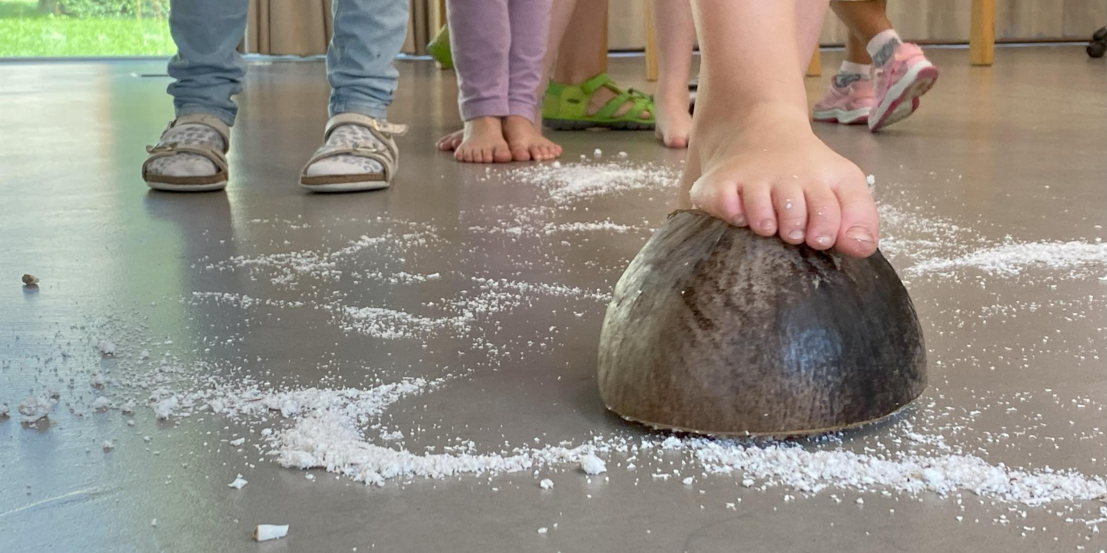 Ein Kind steigt auf eine Kokosnuss